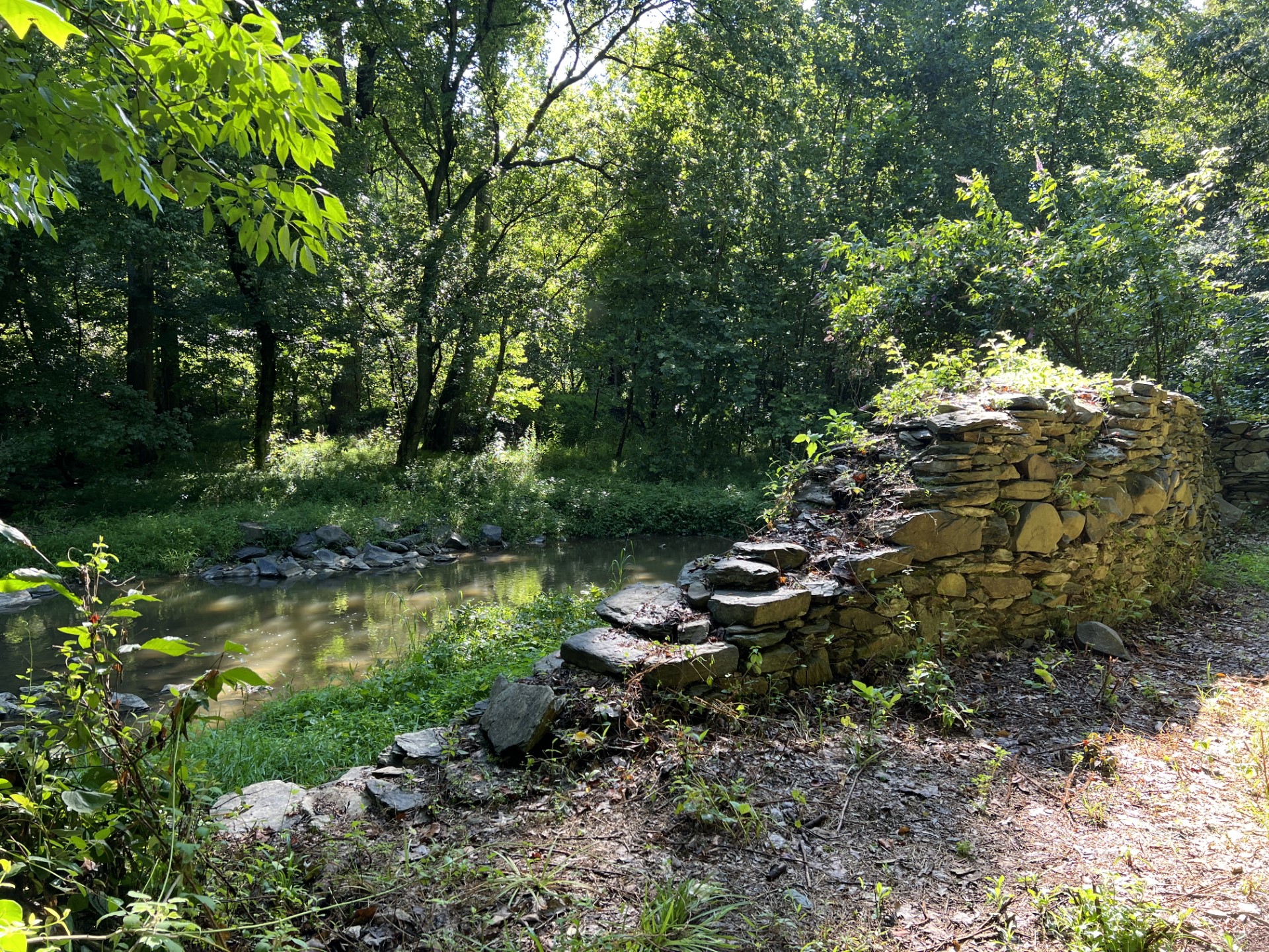 A ruined wall of stone by the river.