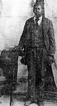 Historic image of a man standing in a suit.