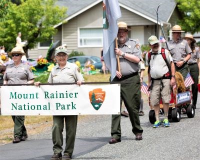 Volunteers in uniform march in a parade.