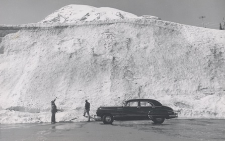 Early park visitors marvel at a snow bank at Paradise, with Mount Rainier in the backdrop. Early park visitors marvel at a snow bank at Paradise, with Mount Rainier in the backdrop.