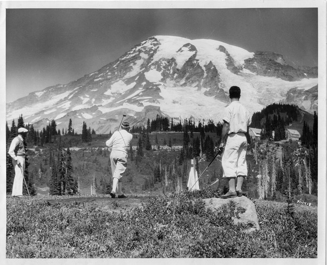 Men golfing with Mount Rainier in the background