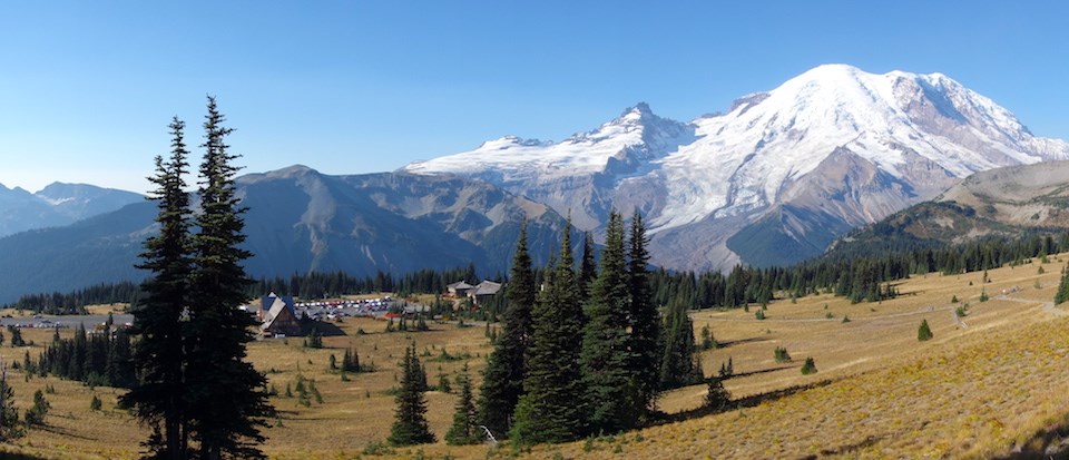 Mount Rainier towers over the meadows and buildings of Sunrise.