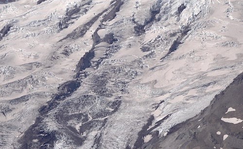 Thin rock ridges descending down the middle of a glacier.