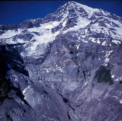 Kautz glacier near the summit of Mount Rainier flowing into a deeply eroded, steep valley.