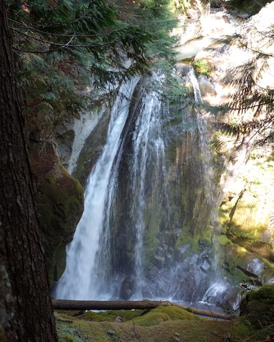 A fan shaped falls dropping over a short cliff partly obscured by the canyon walls.