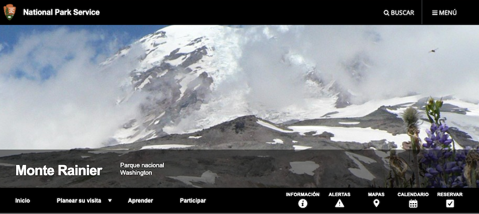 Spanish website banner. A screenshot of a website banner image, showing a mountain wrapped in cloud, and information tabs in Spanish. The page is titled "Monte Rainier".