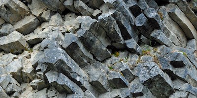 An exposed cluster of hexagonal rock columns in a hillside.