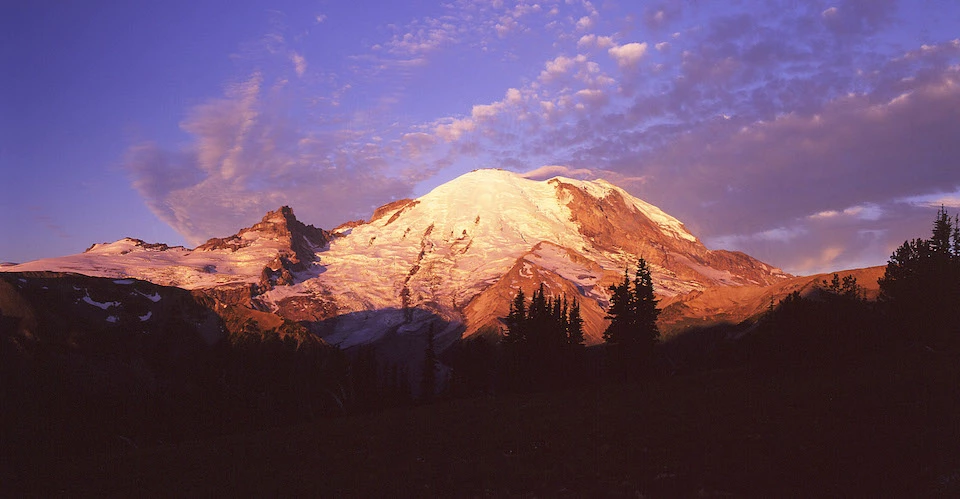 Sunrise from Sunrise A glacier-covered mountain glows pink and red during sunrise.