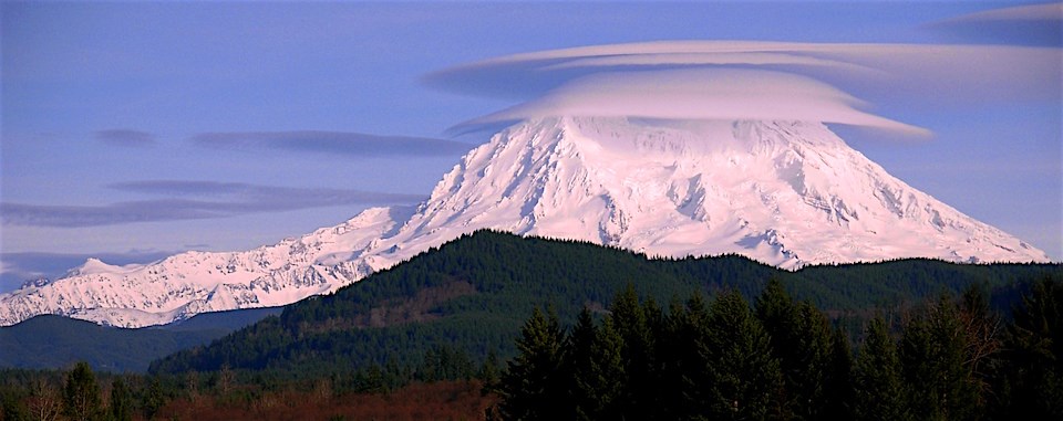 Lenticular, disc-shaped, clouds cling to the peak of Mount Rainier.