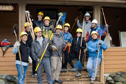 A group of store managers from REI poses on the steps of the National Park Inn after helping with trail maintenance at Longmire