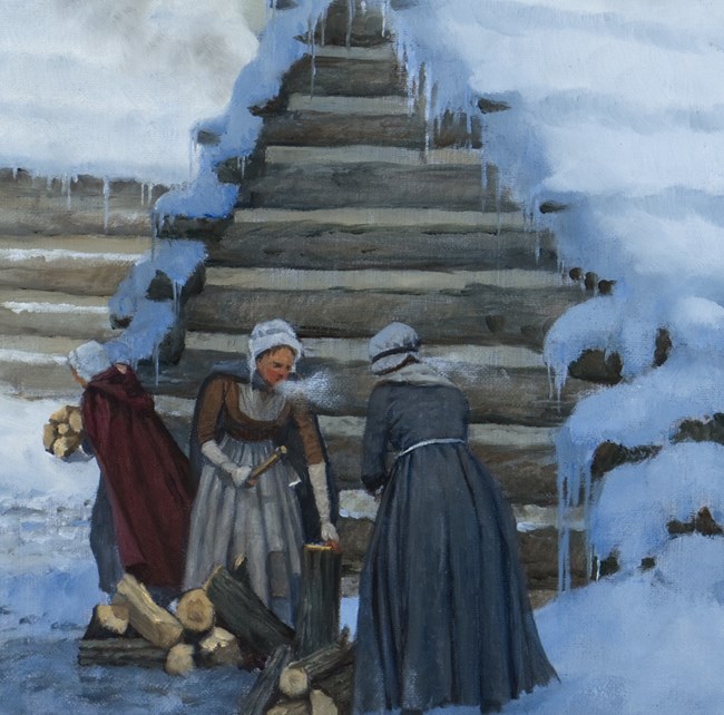 Women standing outside a log hut in the winter