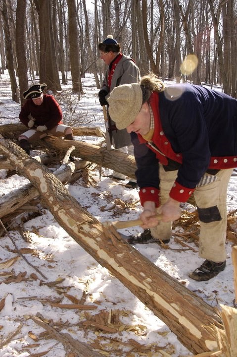 Teacher-Ranger-Teacher Steve Santucci and other re-enactors are cutting and shaping wood to be used in the replica soldier huts they help to maintain