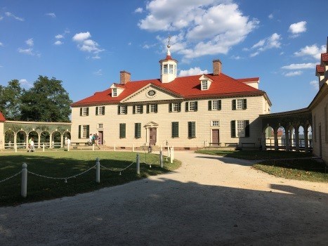 Photograph of Mount Vernon.  Large multi-story cream colored building with red roof.