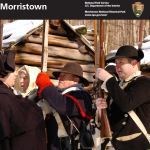 Three people dressed in Colonial costumes on the cover of the junior ranger booklet.