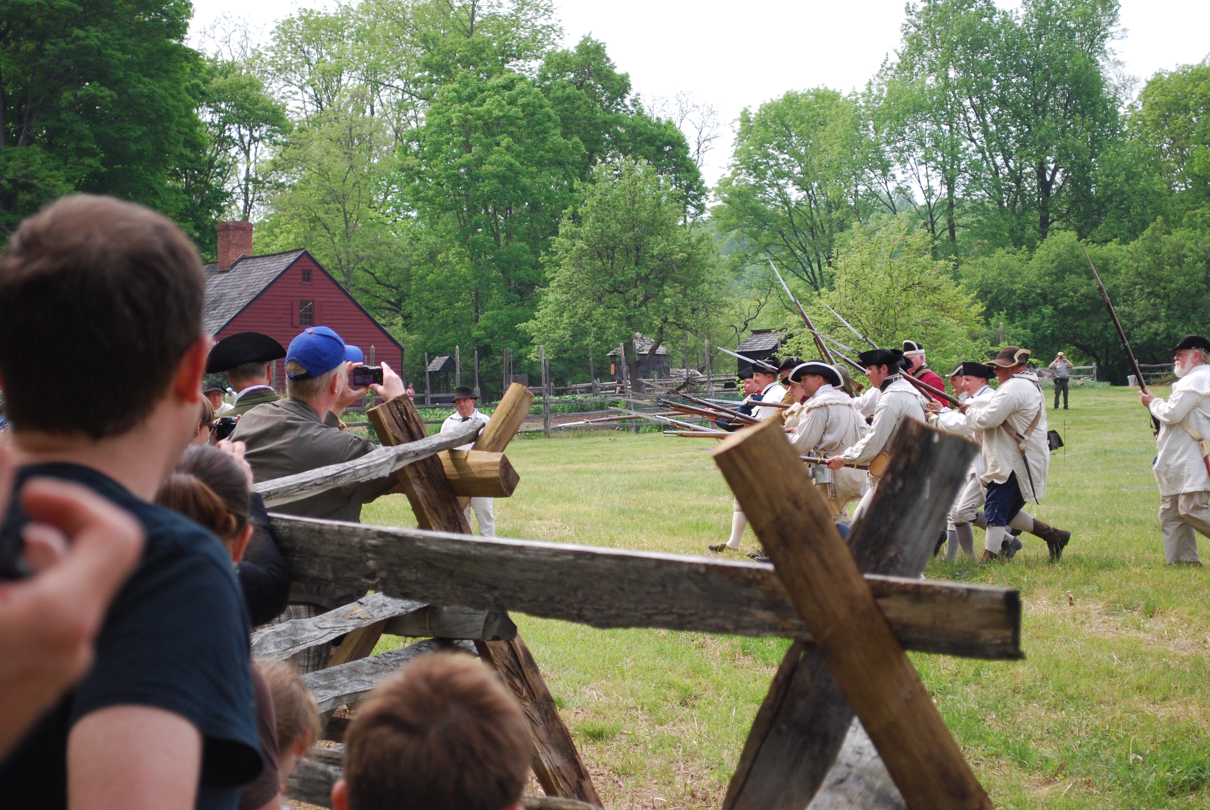 Visitors wiewing musket demonstation by reinactors at Encampment event