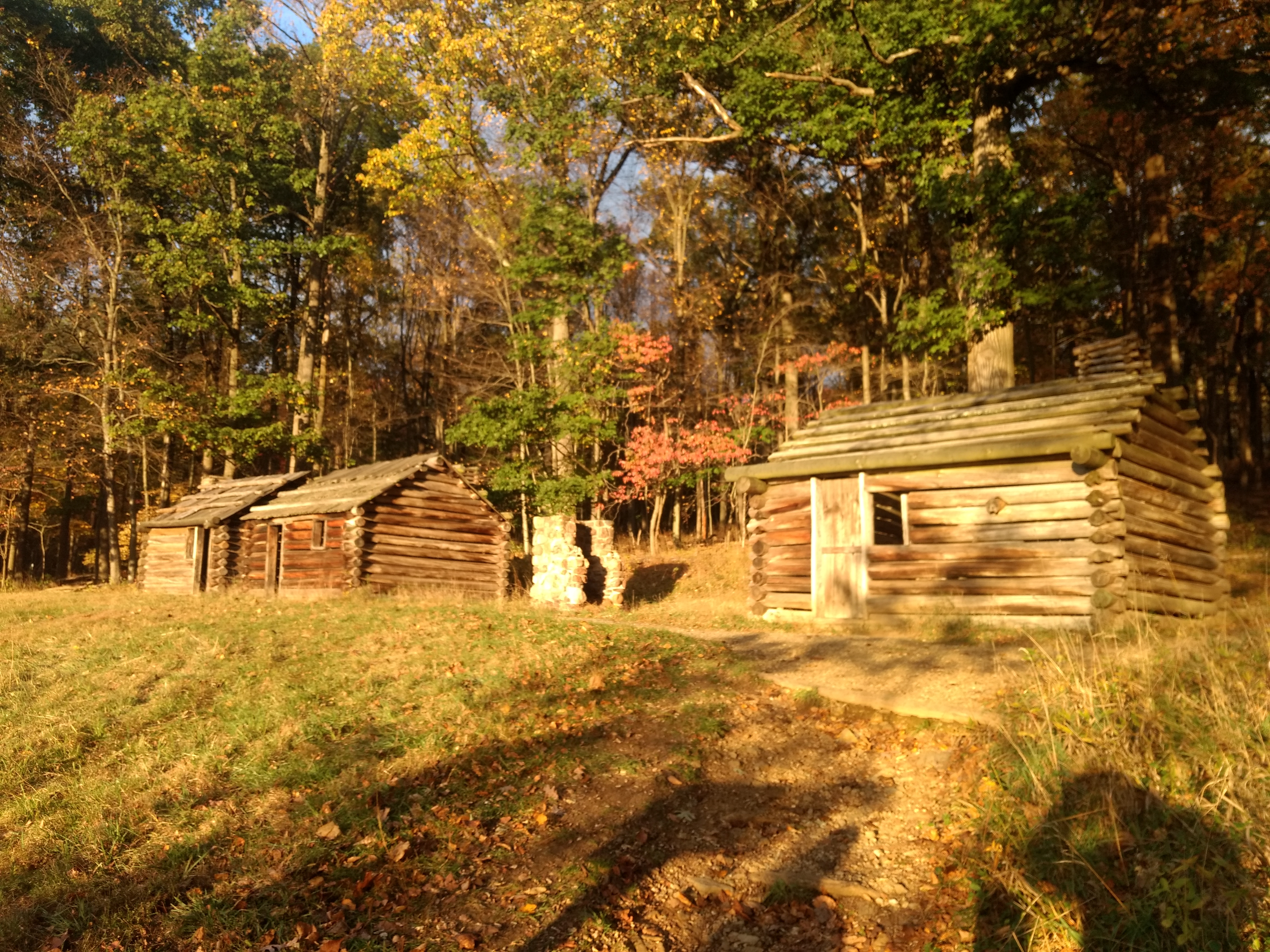 Replica soldier huts. Three one room log building sitting in a row upon a hill in Morristown National Historical Park