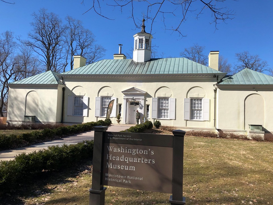 Sign for "Washington's Headquarter's Museum" in front of a one-story white building with a cupola