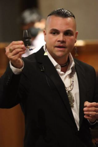 Drew Shuptar-Rayv Drew Shuptar-Rayv in a blue blazar and white shirt holding a small object in his hand