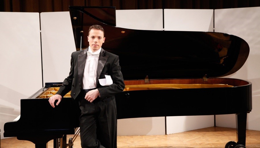 Peter Toth Photograph of Peter Toth in a black tuxedo and white tie standing by a grand piano