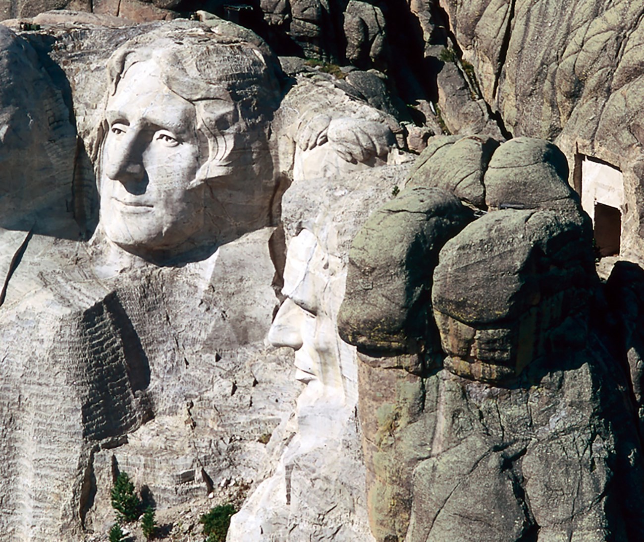 Photo of the location of the Hall of Records across a small valley behind the sculpted heads on Mount Rushmore.