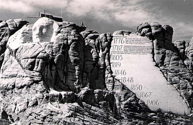 Photo of Mount Rushmore as carving began with conceptual drawing of Borglum's idea for an entablature.