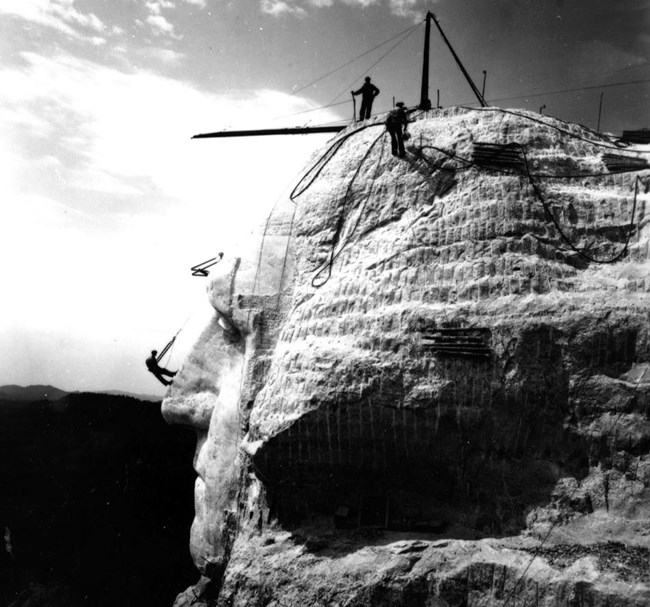 Workers using the pointing system and Bosun chairs on the face of George Washington.