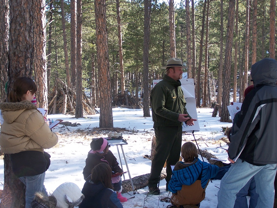 Mount Rushmore Interpretive Park Ranger Blaine Kortemeyer teaches Project Citizen students about the effects of the mountain pine beetle on the ponderosa pine forest.