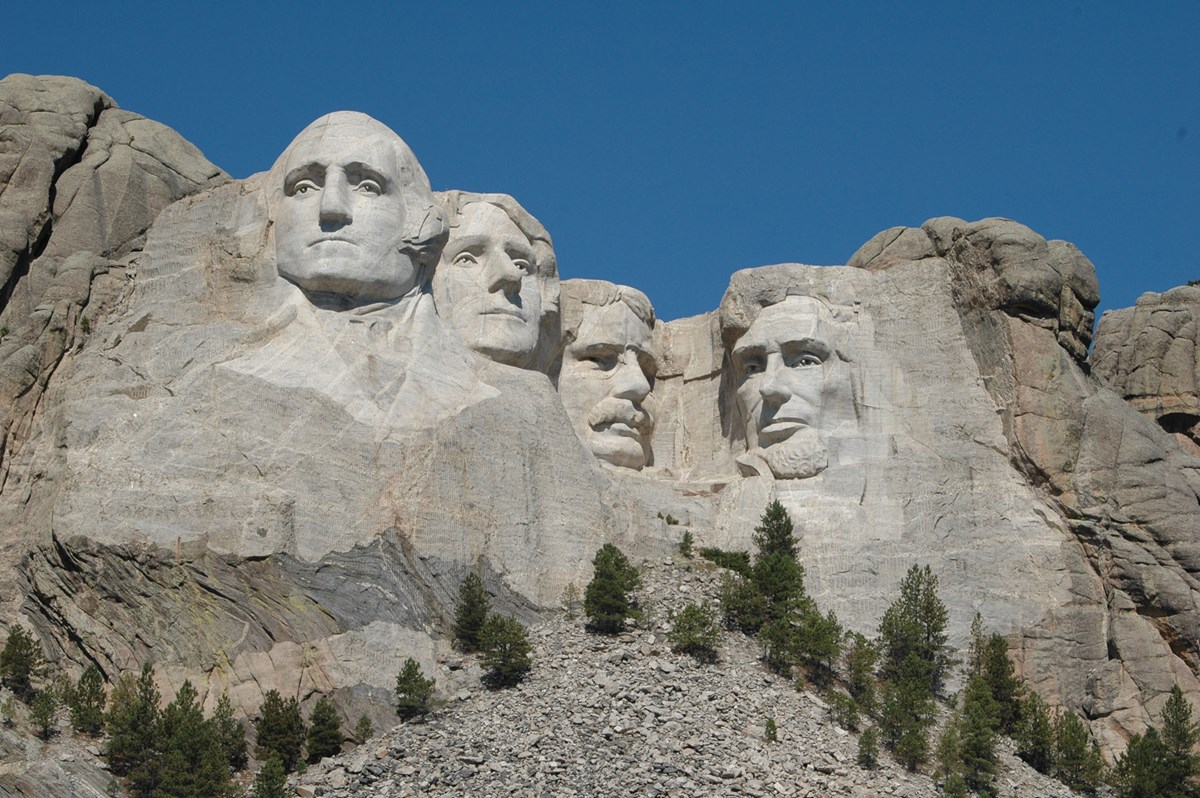 Mount Rushmore under a clear blue sky.