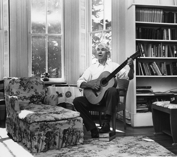 Carl Sandburg plays his guitar in his home