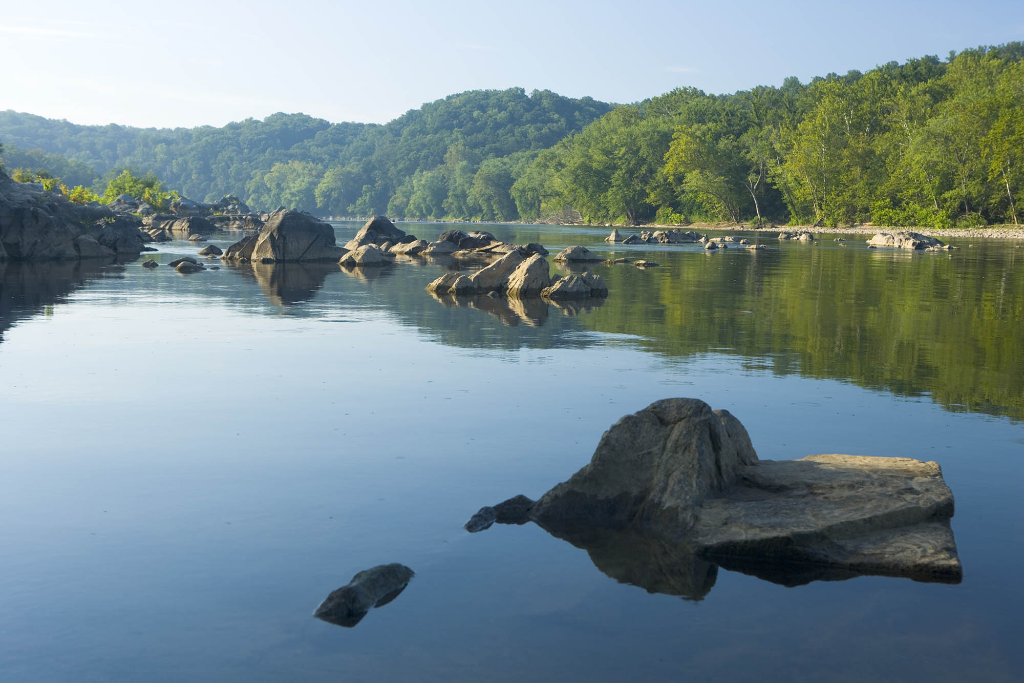 View of a calm Potomac river at Great Falls park with no ripples in the water showing that it is moving quickly
