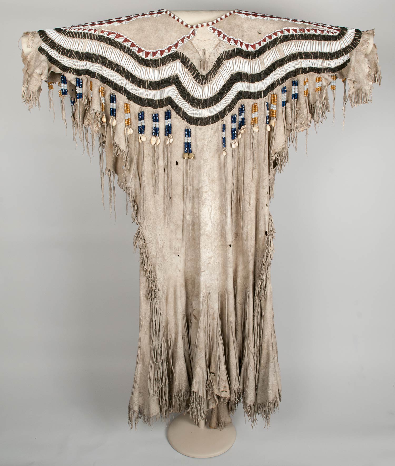 Woman's dress made of two deer skins and decorated with glass beads, dentalium, thimbles, elk teeth, and fringe.