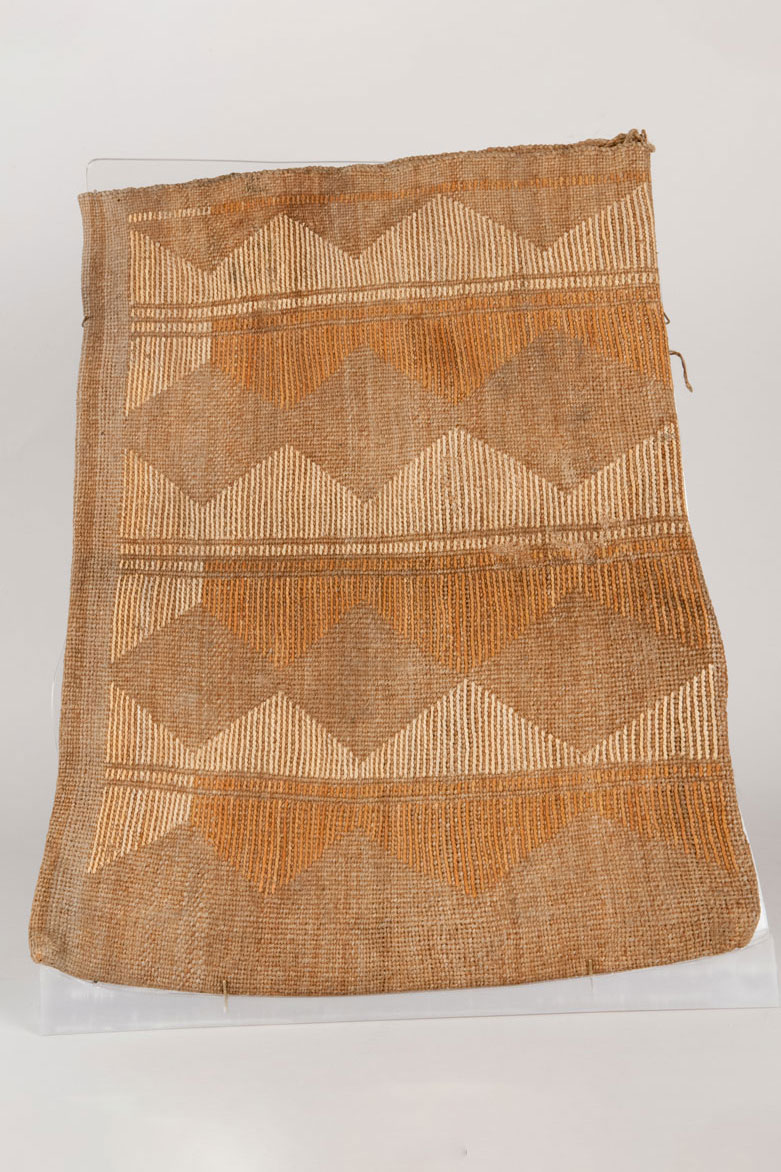 Large, flat cornhusk bag. Constructed using plain twining of Indian hemp with dyed and undyed cornhusk false embroidery. Geometric hourglass figures featured on both sides.