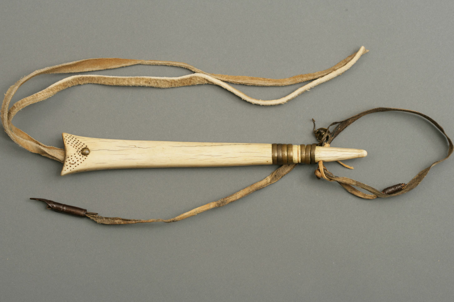 Decorated elk antler horse quirt or whip. The handle is formed of a piece of rawhide thong to which a forged iron ram rod is attached at one end.