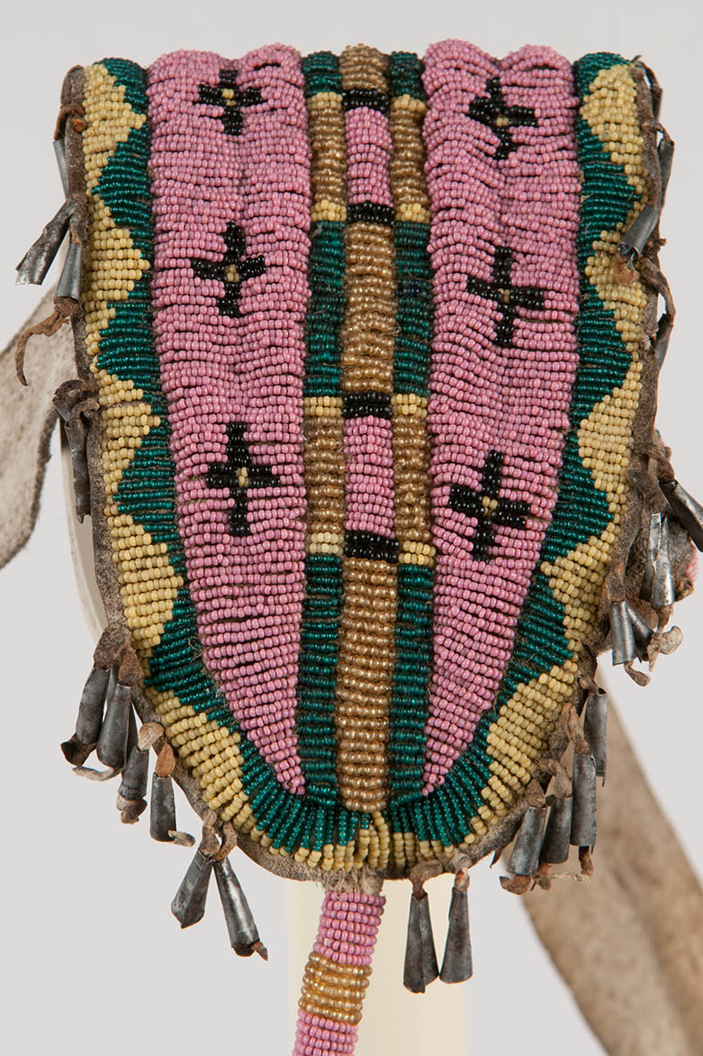 Beaded and tin cone pouch attached to a hide belt.