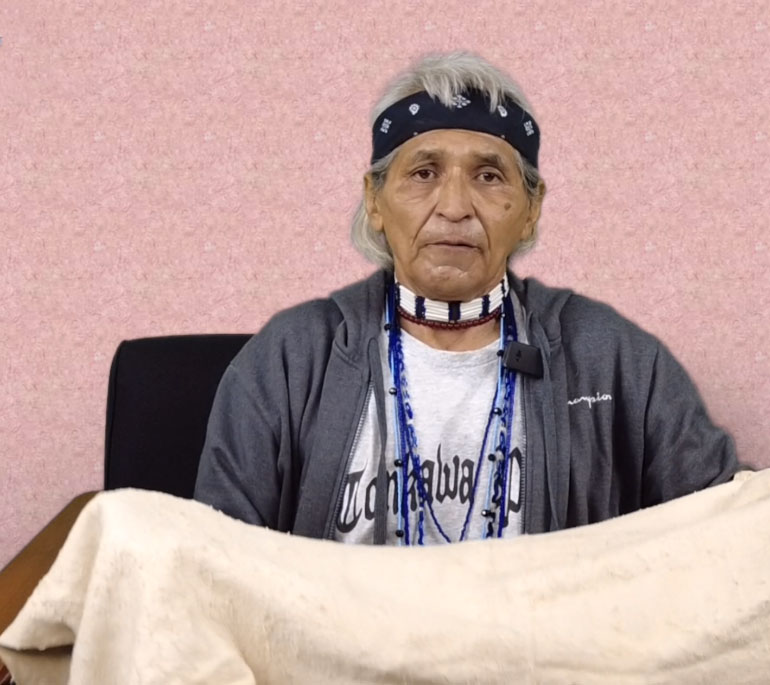 Native American man holding a piece of hide