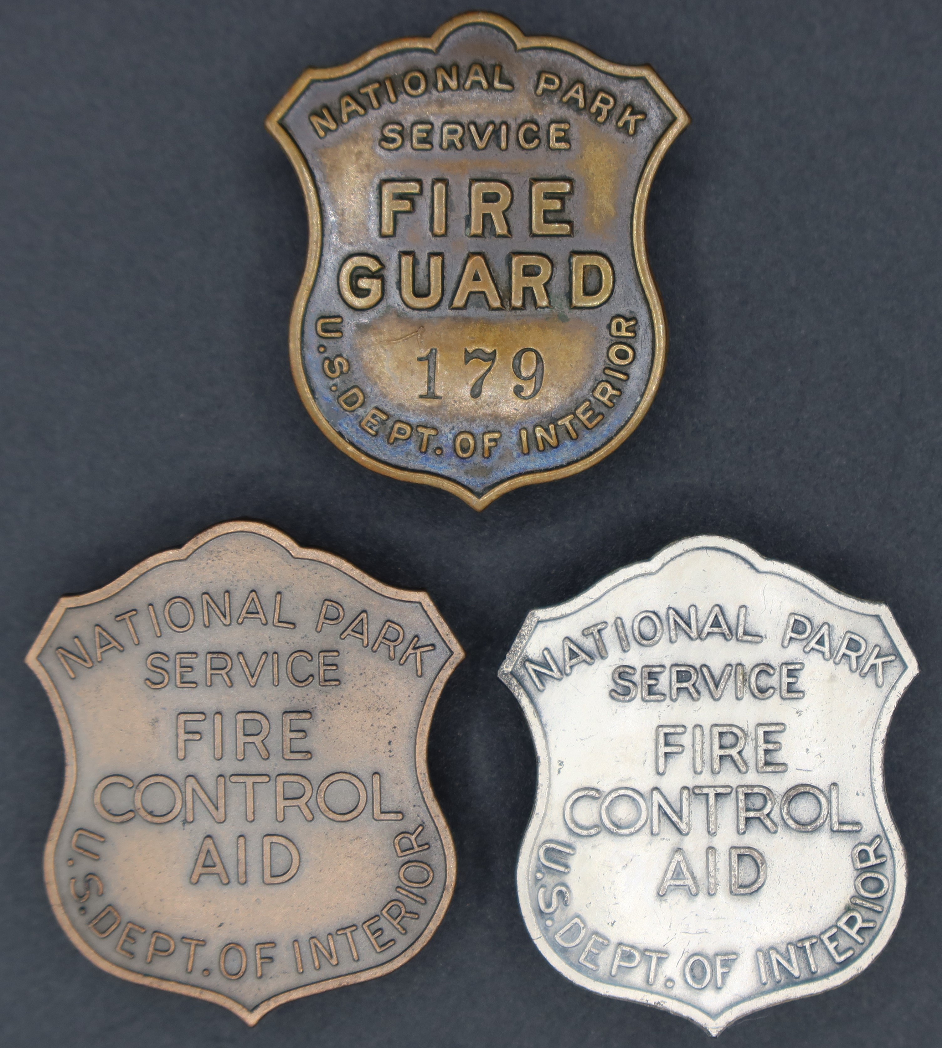 Shield-shaped badges marked, National Park Service and US Depart of Interior. One marked Fire Guard and 179. Two marked Fire Control Aid.