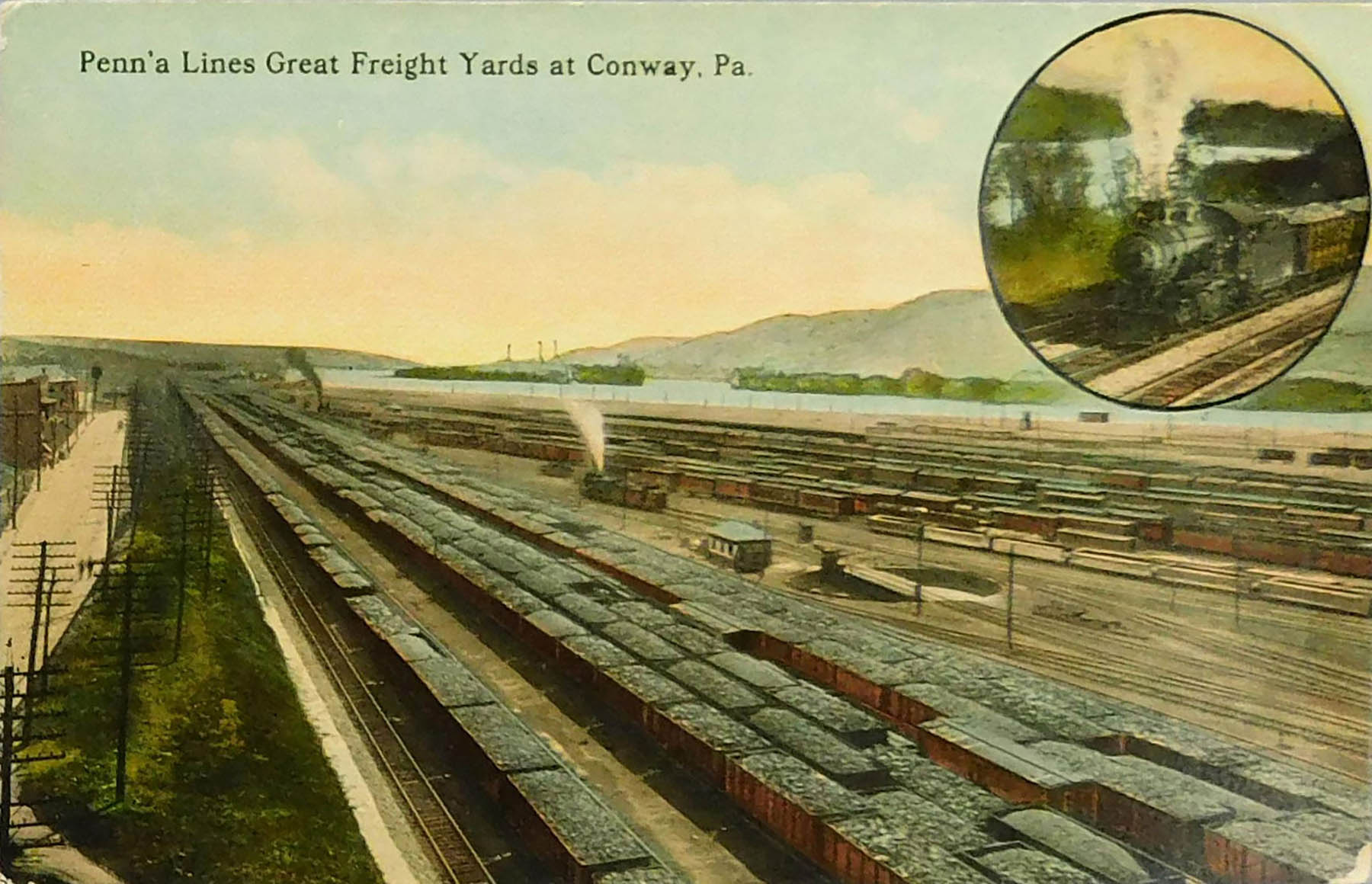 Penn'a Lines Great Freight Yards At Conway, PA. colored photo of many loaded hopper cars. Circular inset of steam locomotive. Turntable in center; mountains and river in background.