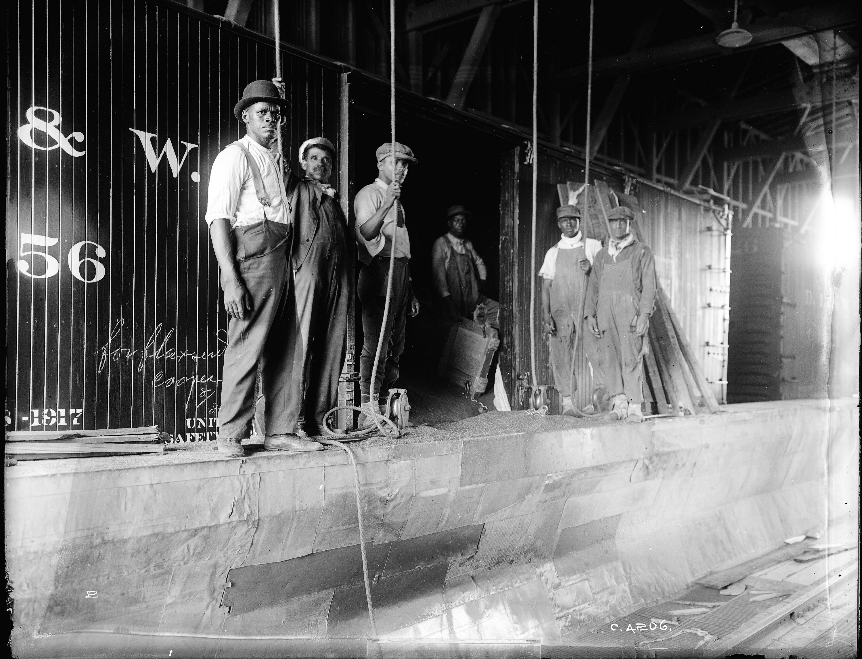 Laborers in front of grain boxcar