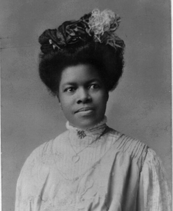 A black and white photo of a young Nannie Helen Burroughs wearing a black hat