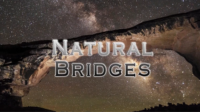 The text 'Natural Bridges' on top of a stone natural bridge with a starry night sky in the background.