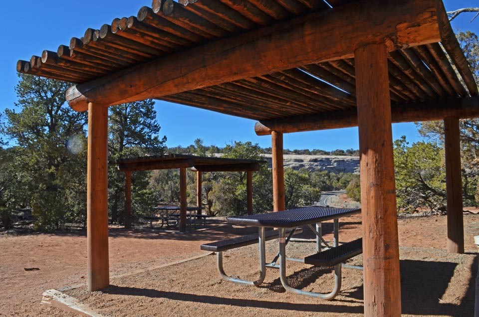 two picnic tables covered with shade structures