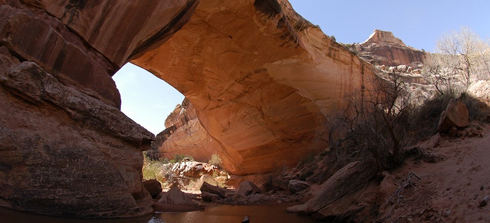 a thick, stone bridge with water at the base