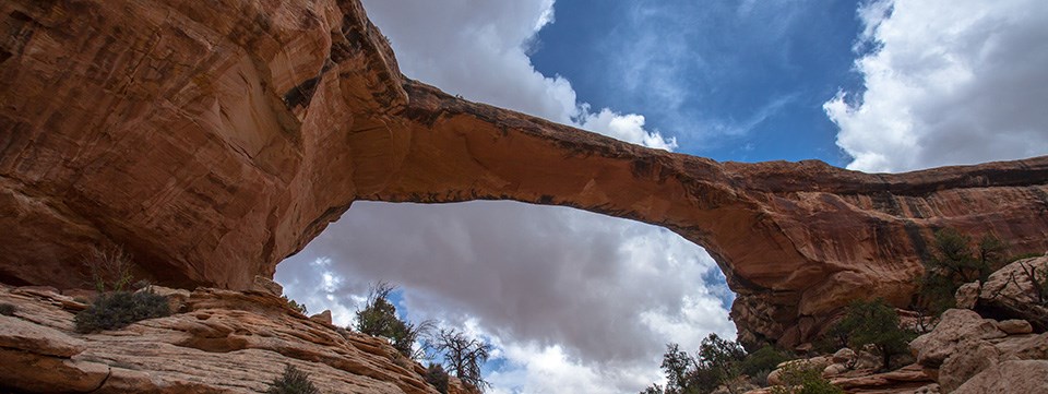 A broad, stone bridge under a blue sky with clouds