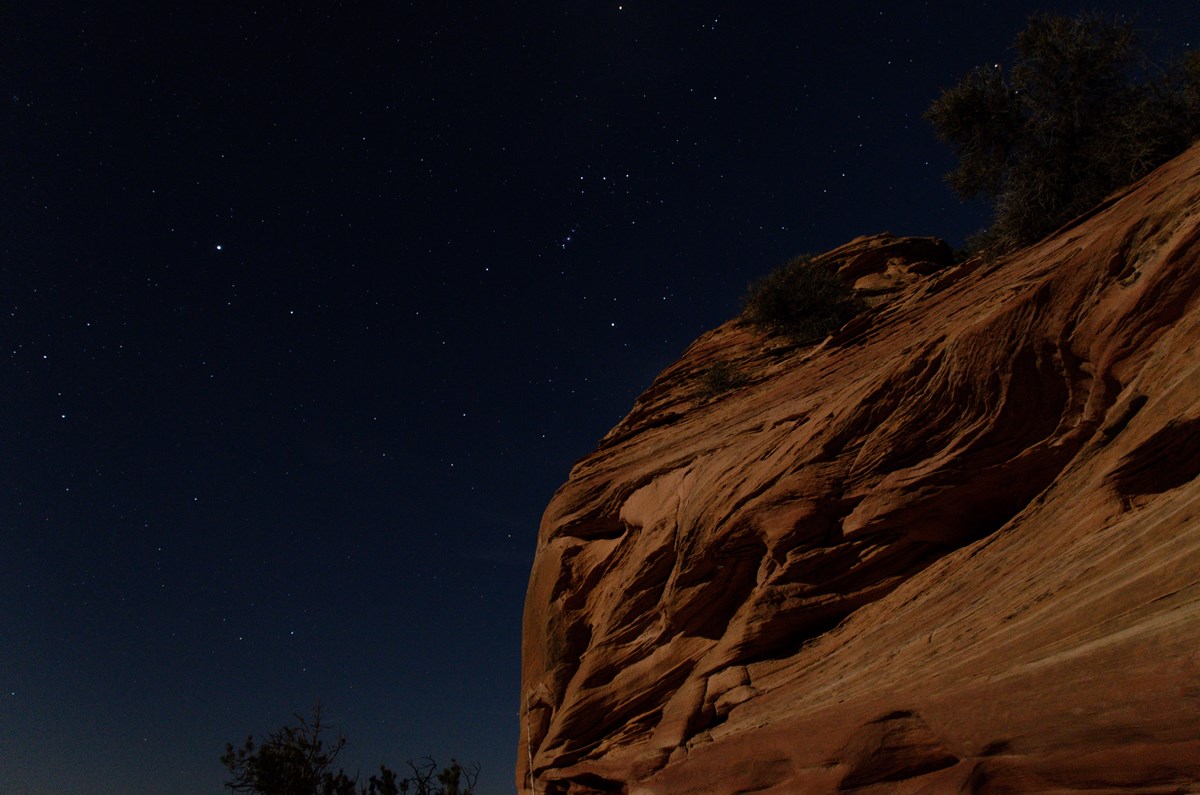 sandstone illuminated by moonlight, with starry sky behind