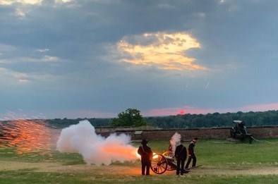 A crew of three people firing a cannon.