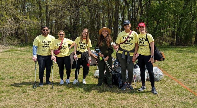 A group of people standing with trash grabbers.