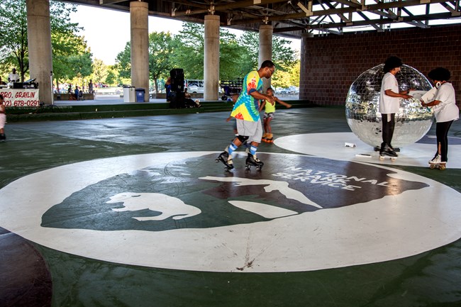 A roller-skater rides across the center of a skating rink.