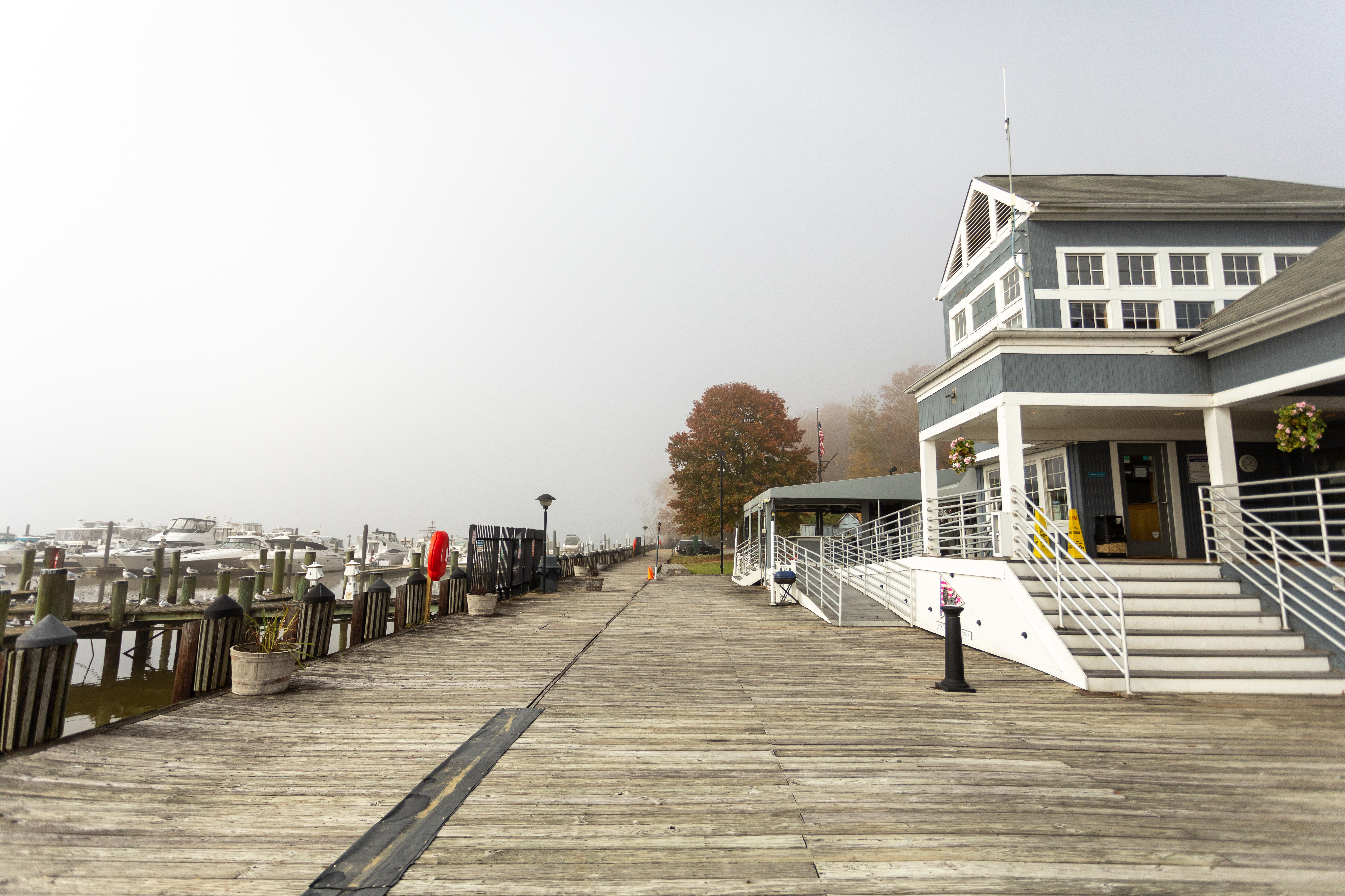 Fort Washington Marina A wooden boardwalk extends to the horizon adjacent to stairs leading up to a two-story building.