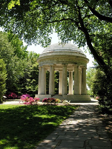 Trees surround the white marble columns of the DC War Memorial