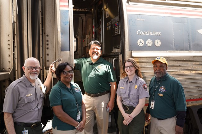 Volunteers and Park Rangers next to a train